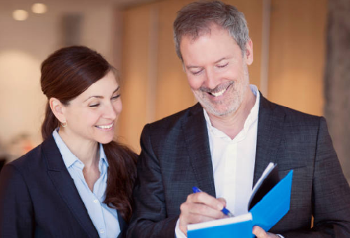 An Entrepreneur signs a copy of his book for a new client